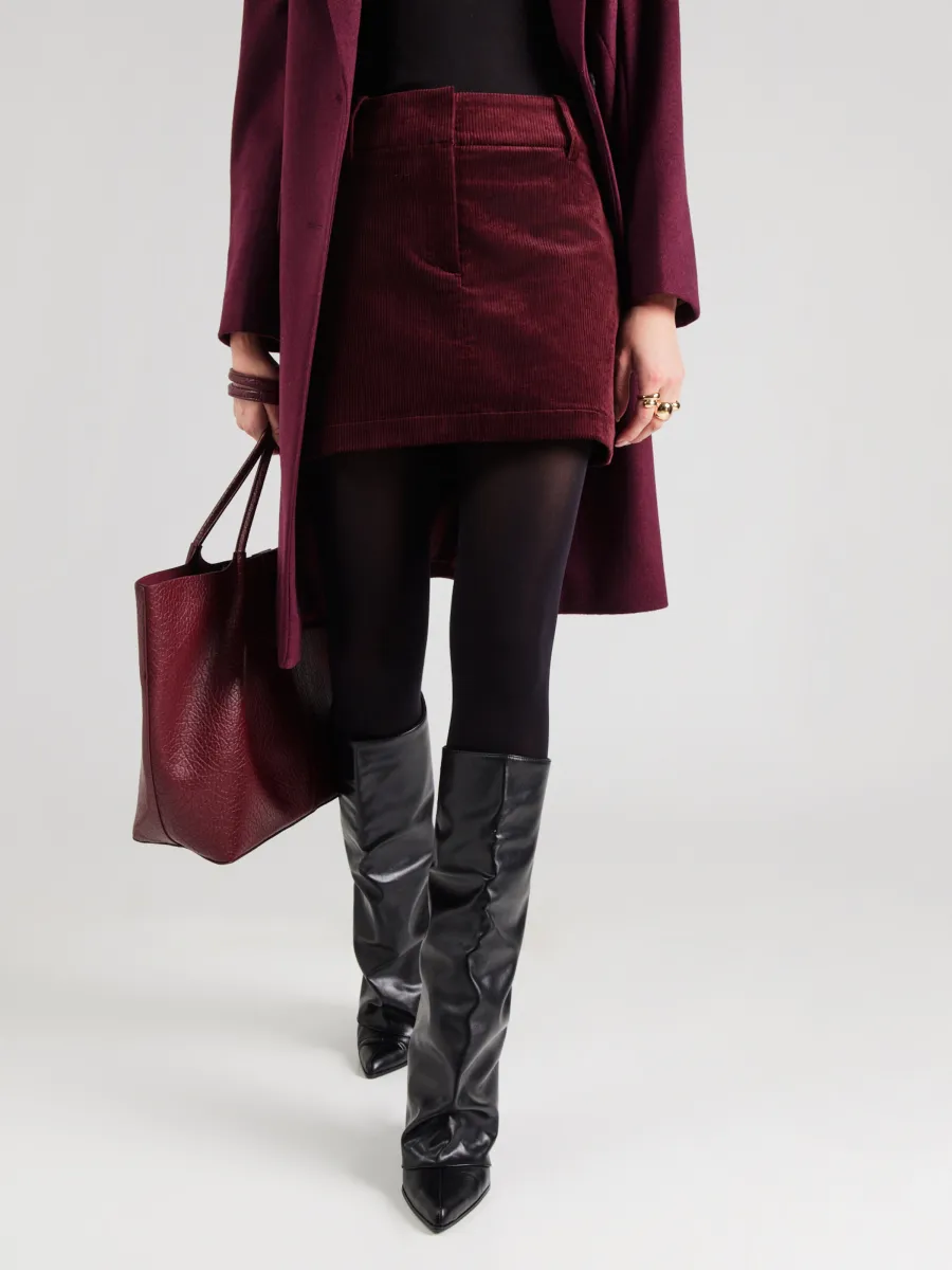 Woman in burgundy corduroy mini skirt with tights