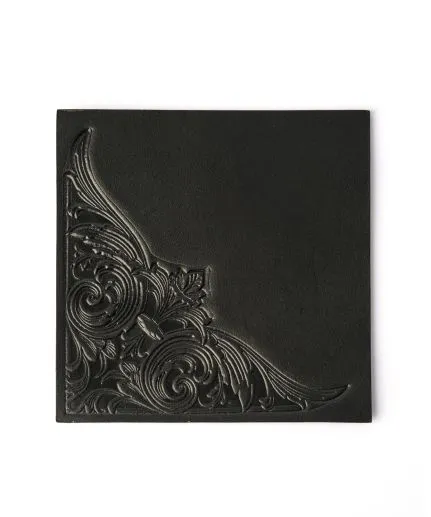 Square-shaped leather coaster with embossed detail on the corner